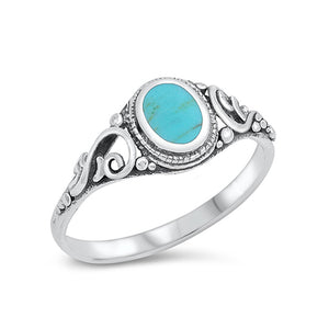  Pretty silver bohemian ring with an oxidised finish embellished with a simulated turquoise stone. The band of the ring either side of the stone is decorated with an intricate swirl design.